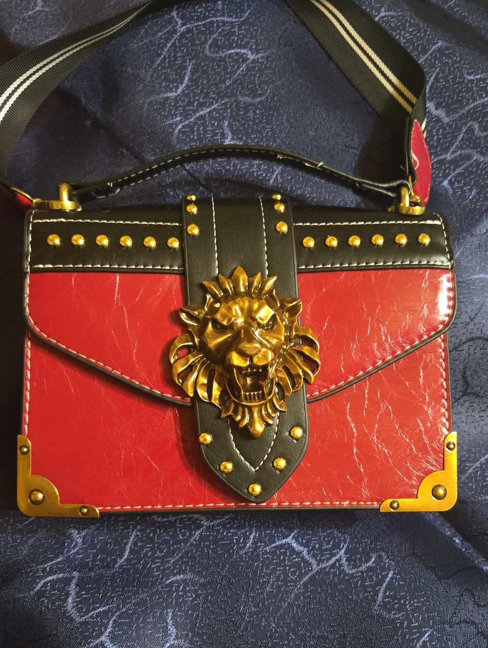 Darj Red  Leather Lion-Embellished Hand Bag With A Soft  Shoulder Strap.
